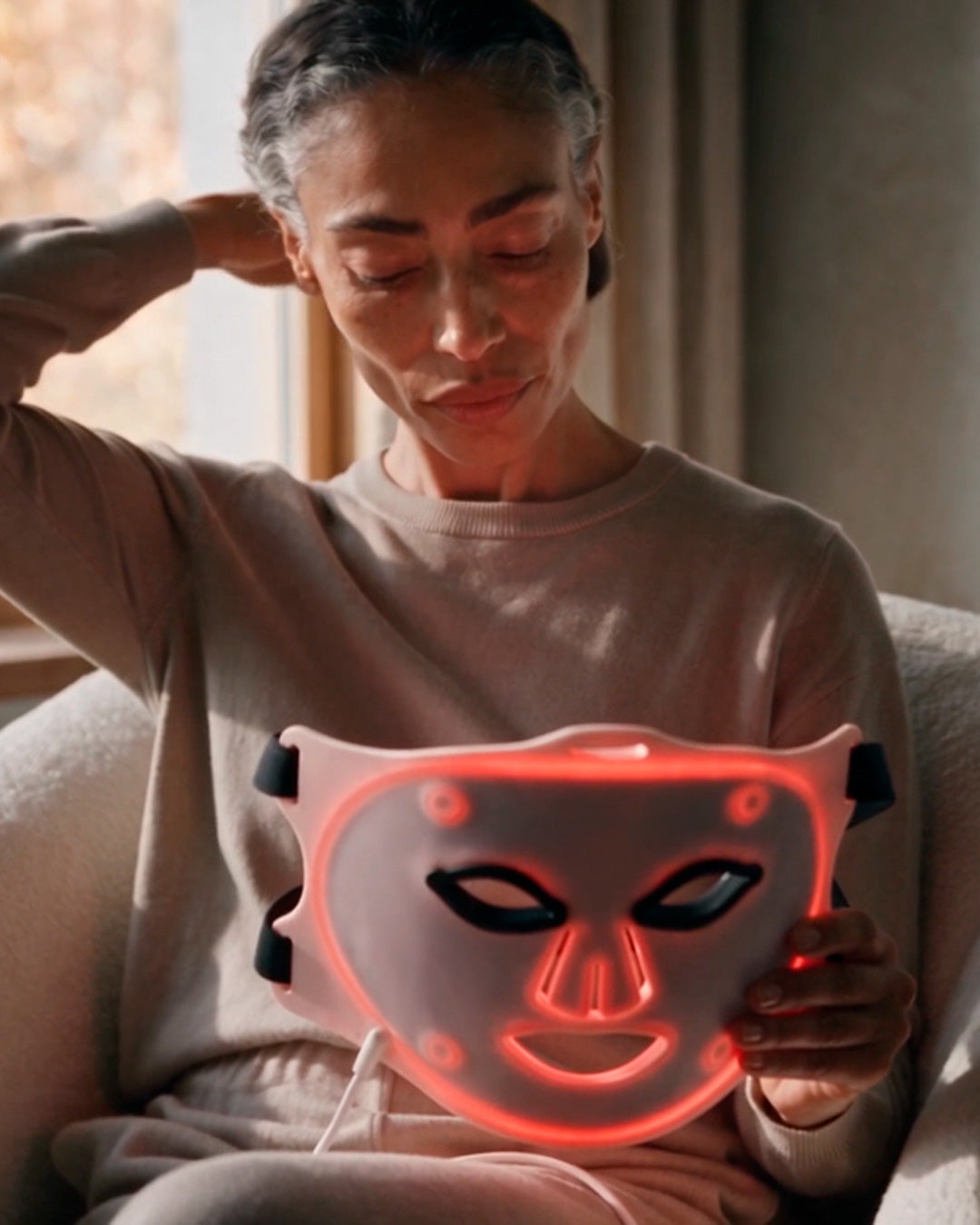 Mujer sosteniendo la máscara LED facial de Saglou
